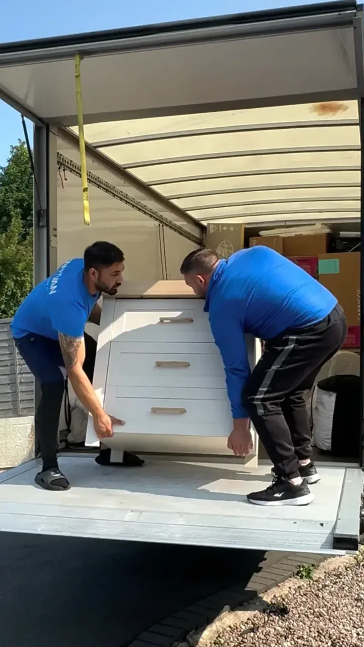 Moving specialists loading a chest of drawers safely into the van