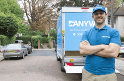 AnyVan driver carrying a stack of moving boxes
